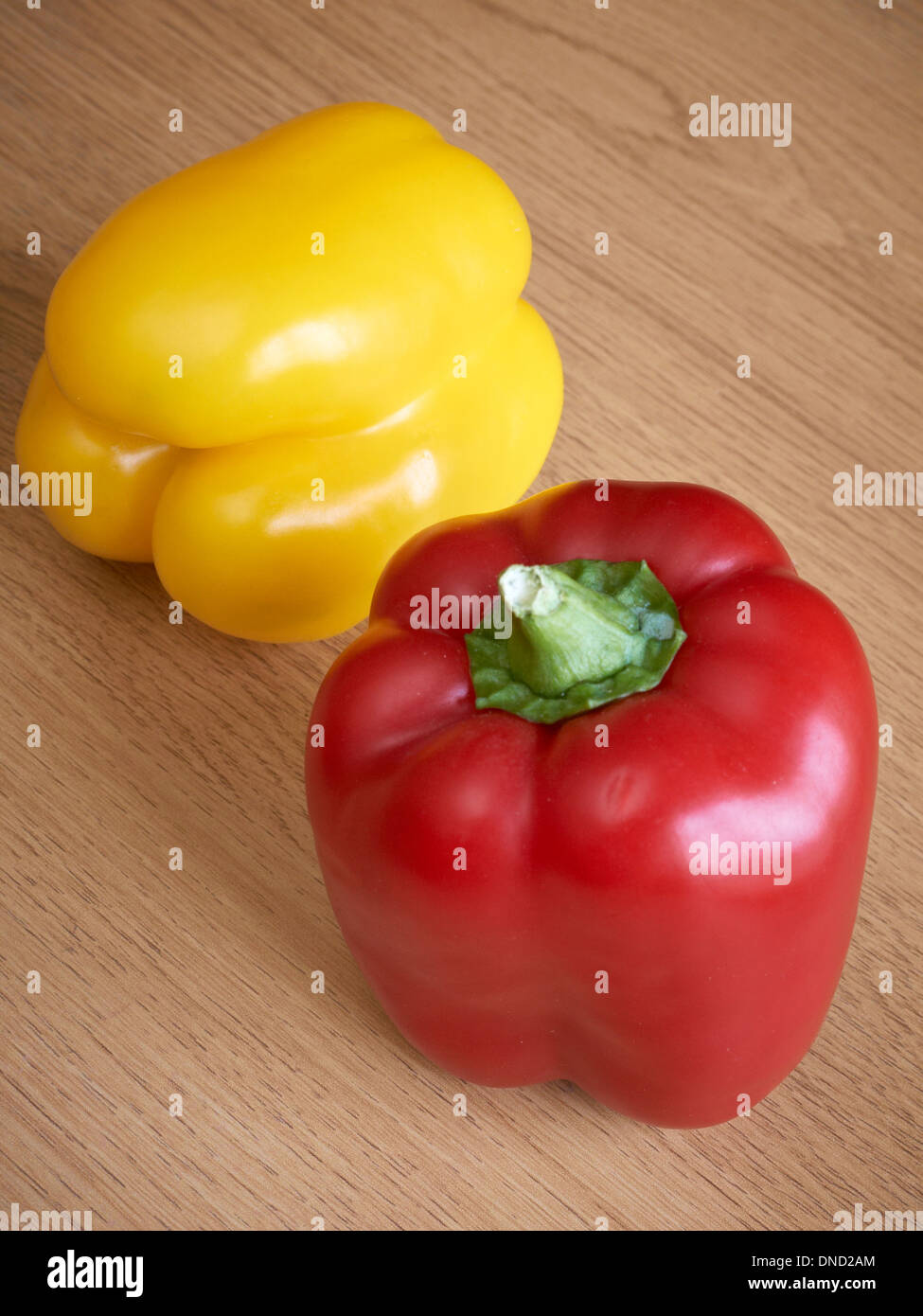 Red and yellow peppers on chopping board Stock Photo - Alamy
