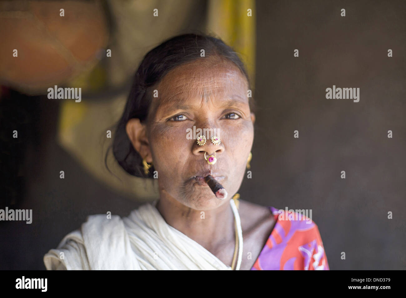 Close-up of an old tribal woman smoking bidi, an Indian handmade cigarette made of tobacco or beedi leaves, Orissa, India. Rural faces of India Stock Photo