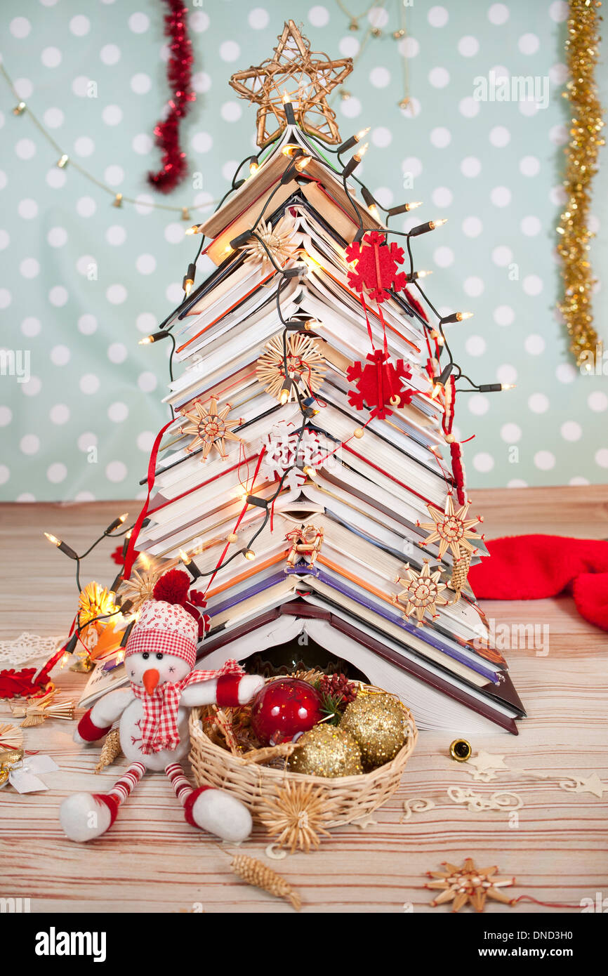 Christmas tree made of books and funny snowman Stock Photo Alamy