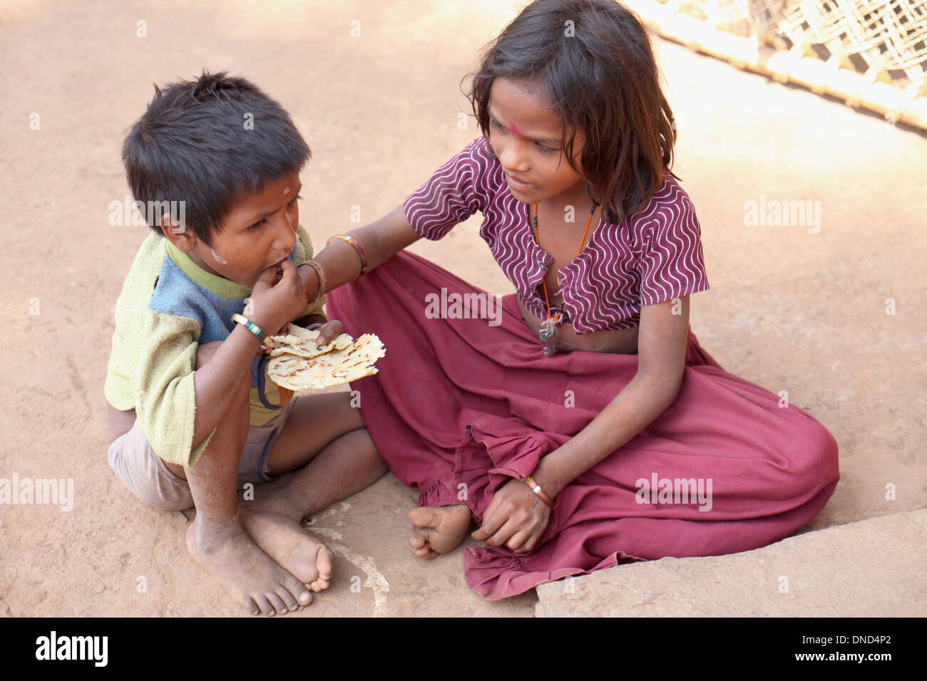 Tribal children having lunch eating dry chapati, Madhya Pradesh, India Stock Photo