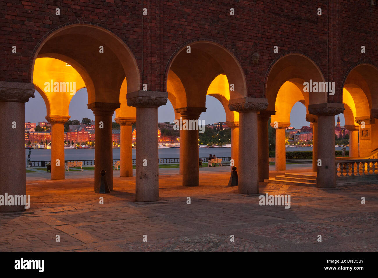 Evening view of the colonnade and Riddarfjärden beyond, from the piazza of Stockholm City Hall (Stockholms stadshus) (1911-1923) Stock Photo