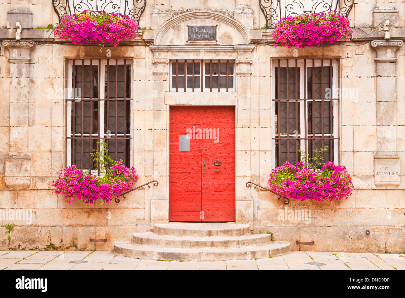 A colourful display of flowers on the front of the mairie of Noyers sur Serein in Burgundy. Stock Photo