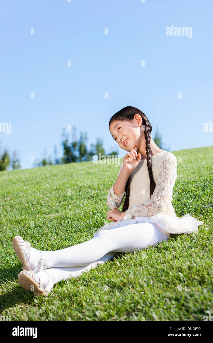 Lovely girl sitting on the lawn in a park Stock Photo - Alamy