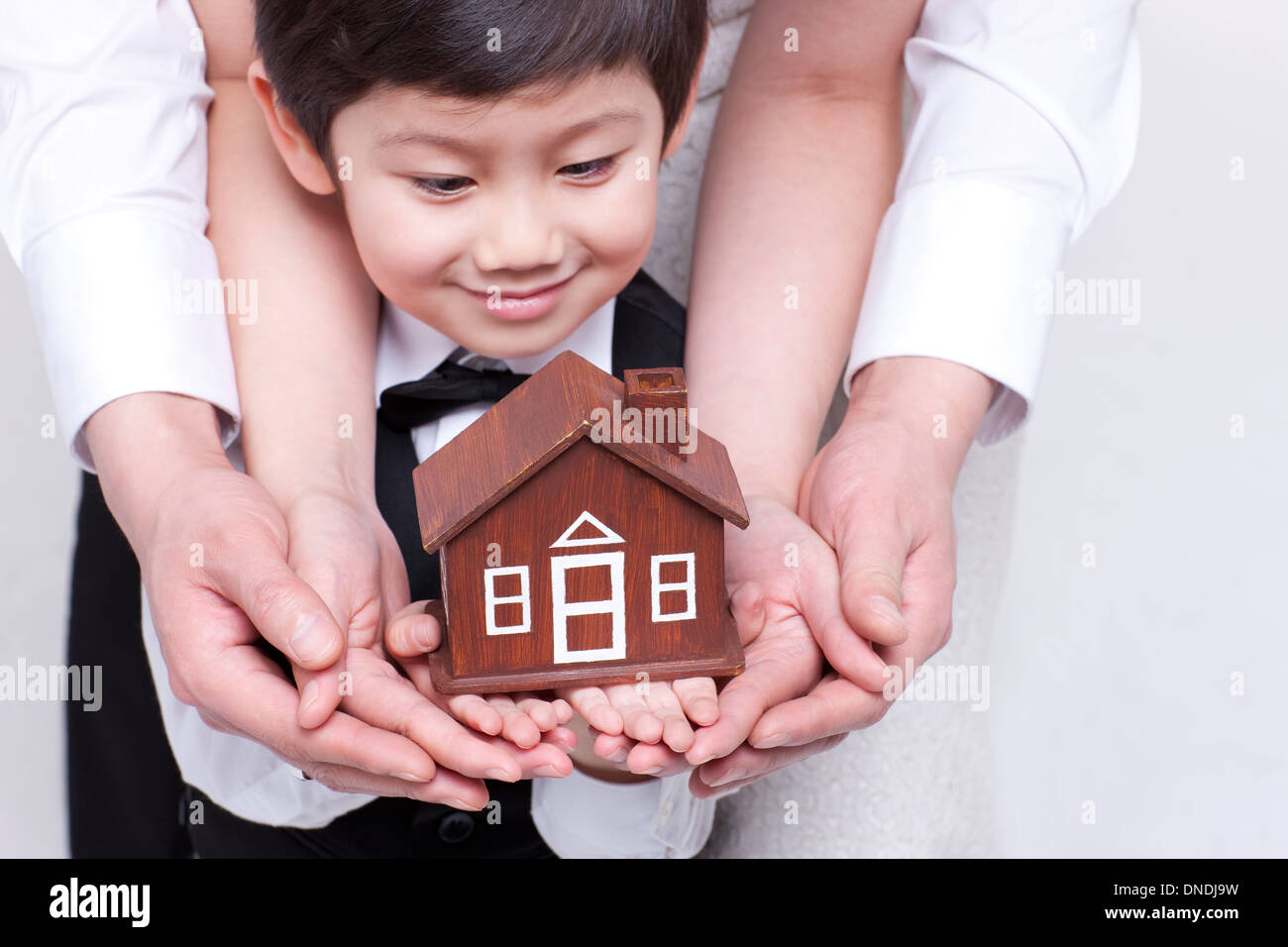 Family holding hands with house model Stock Photo - Alamy