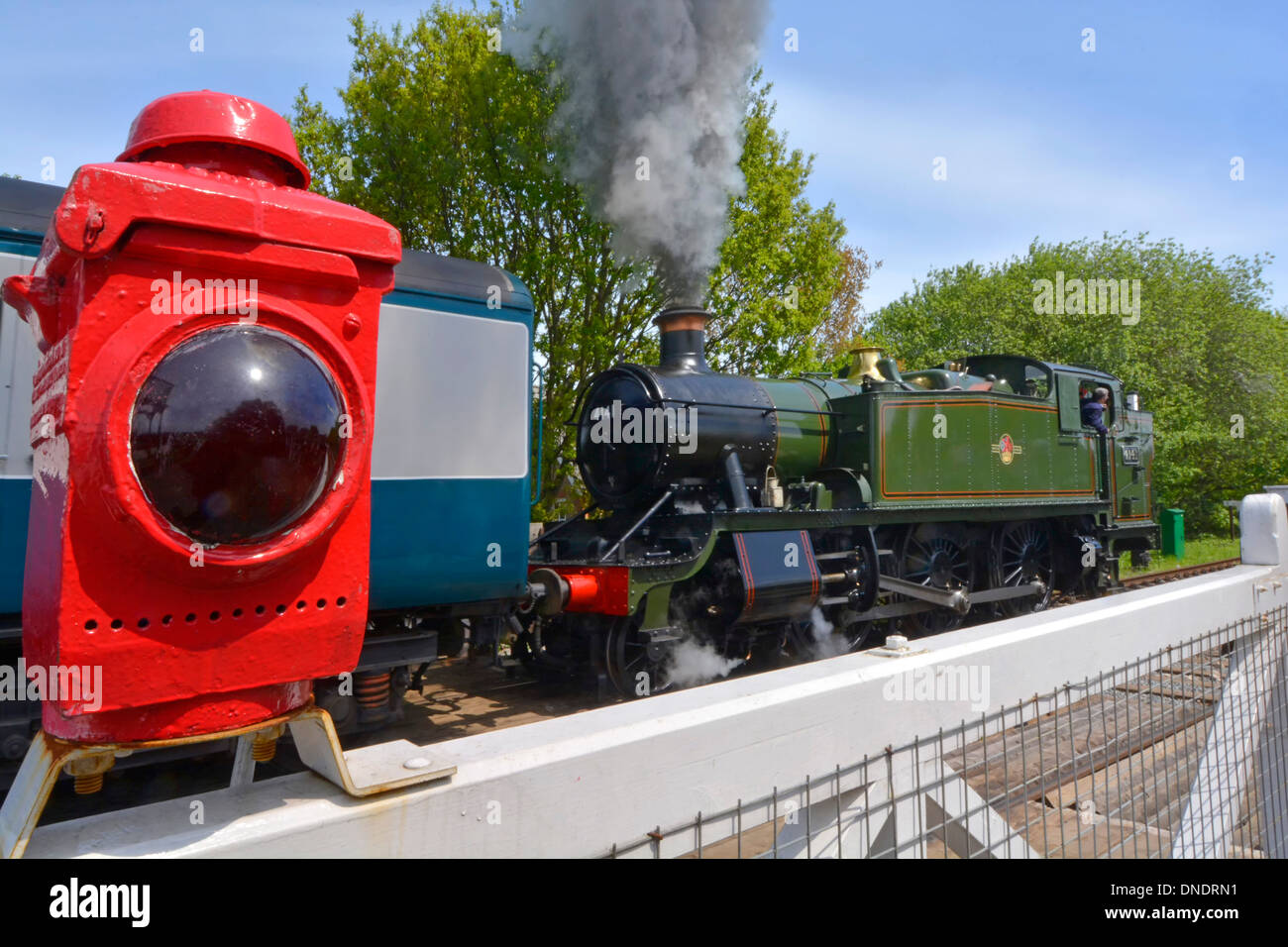 Steam locomotive 4141 departing North Weald station on the Epping Ongar heritage railway at North Weald level crossing gates Stock Photo