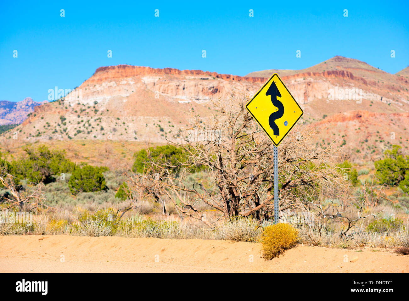 Desert road with winding road sign Stock Photo