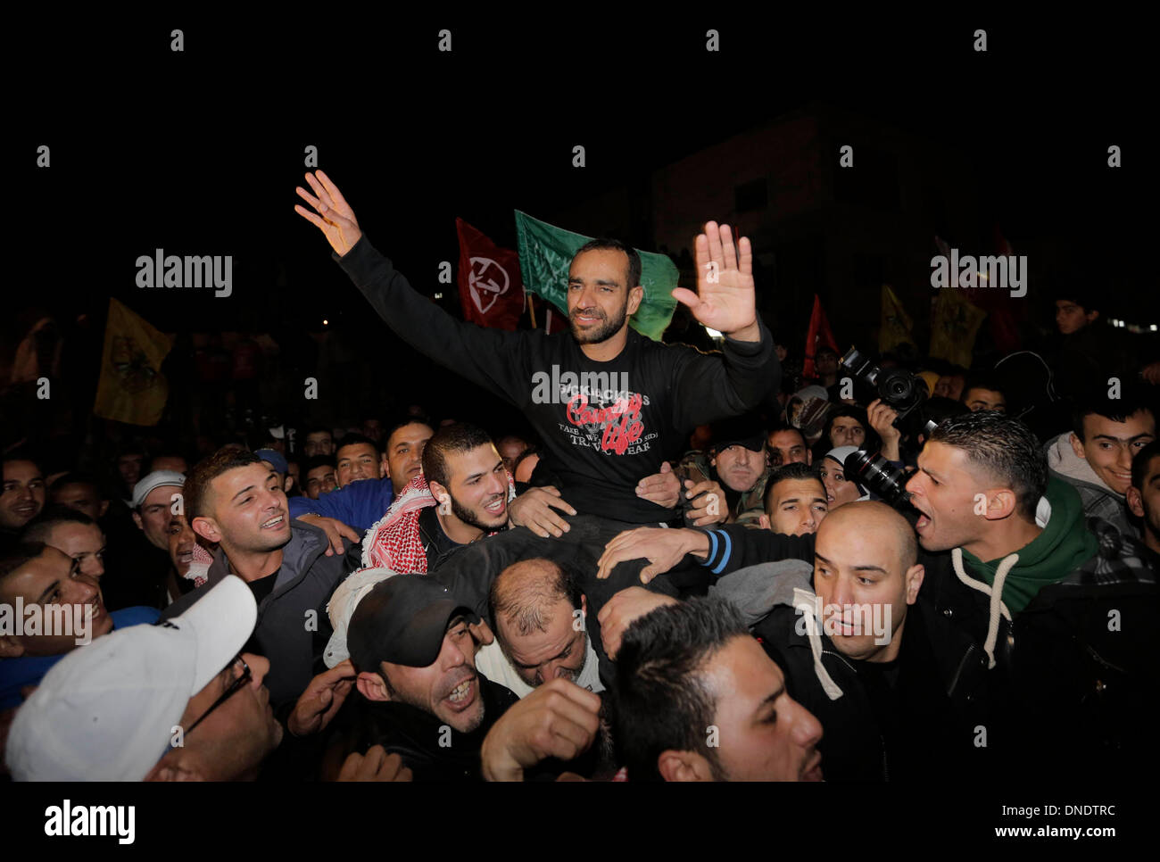 Jerusalem. 23rd Dec, 2013. Palestinians carry released Palestinian prisoner Samer Essawi (C) as they celebrate in Essaweyeh town in eastern Jerusalem, on Dec. 23, 2013. Israeli authorities on Monday released Samer Essawi, a Palestinian prisoner who went on the longest hunger strike against Israel, after more than 17 months in jail, his families told reporters. Credit:  Muammar Awad/Xinhua/Alamy Live News Stock Photo