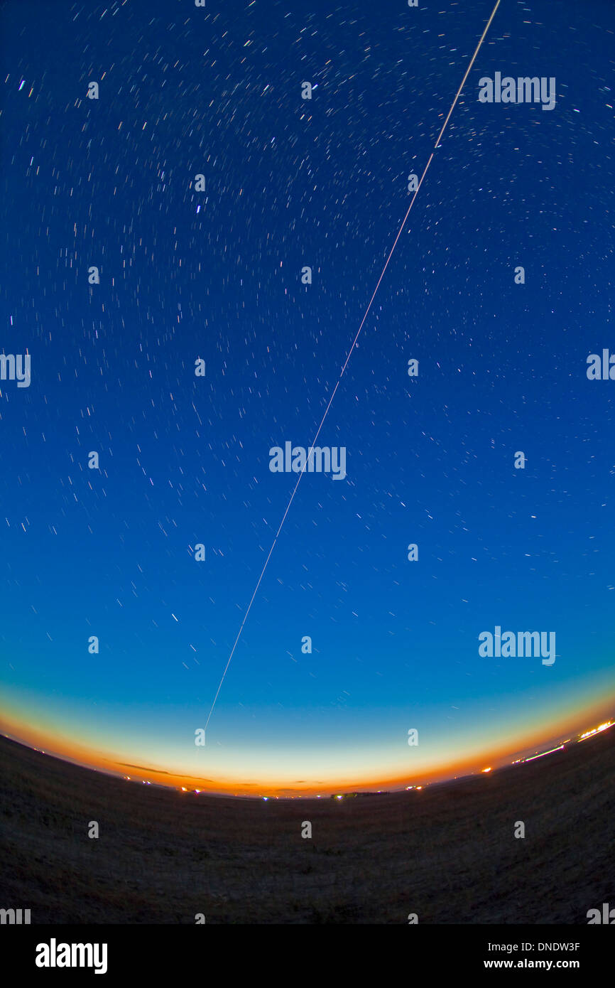 Trail of the International Space Station coming out of the western twilight. Stock Photo