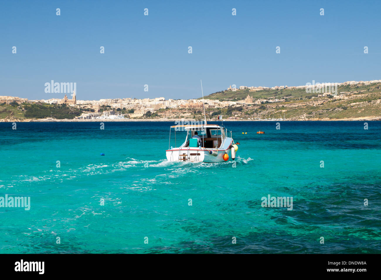 A view of a ferry passing through the Blue Lagoon, Comino, with the