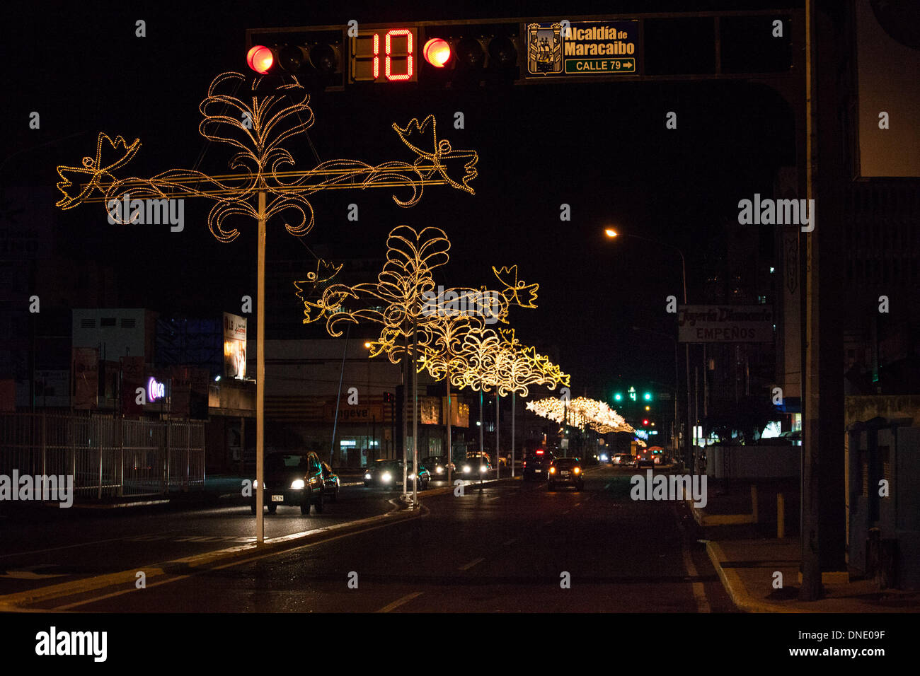Maracaibo, Venezuela. 23rd Dec, 2013. Vehicles drive on a street decorated with Christmas lights in the city of Maracaibo, Zulia State, Venezuela, on Dec. 23, 2013. Credit:  Boris Vergara/Xinhua/Alamy Live News Stock Photo