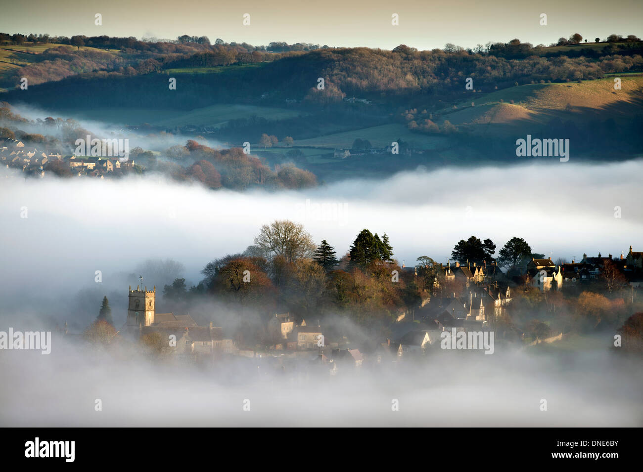 Misty morning in the Stroud Valley, Gloucestershire with St Mary Magdalene Church in Rodborough UK Stock Photo