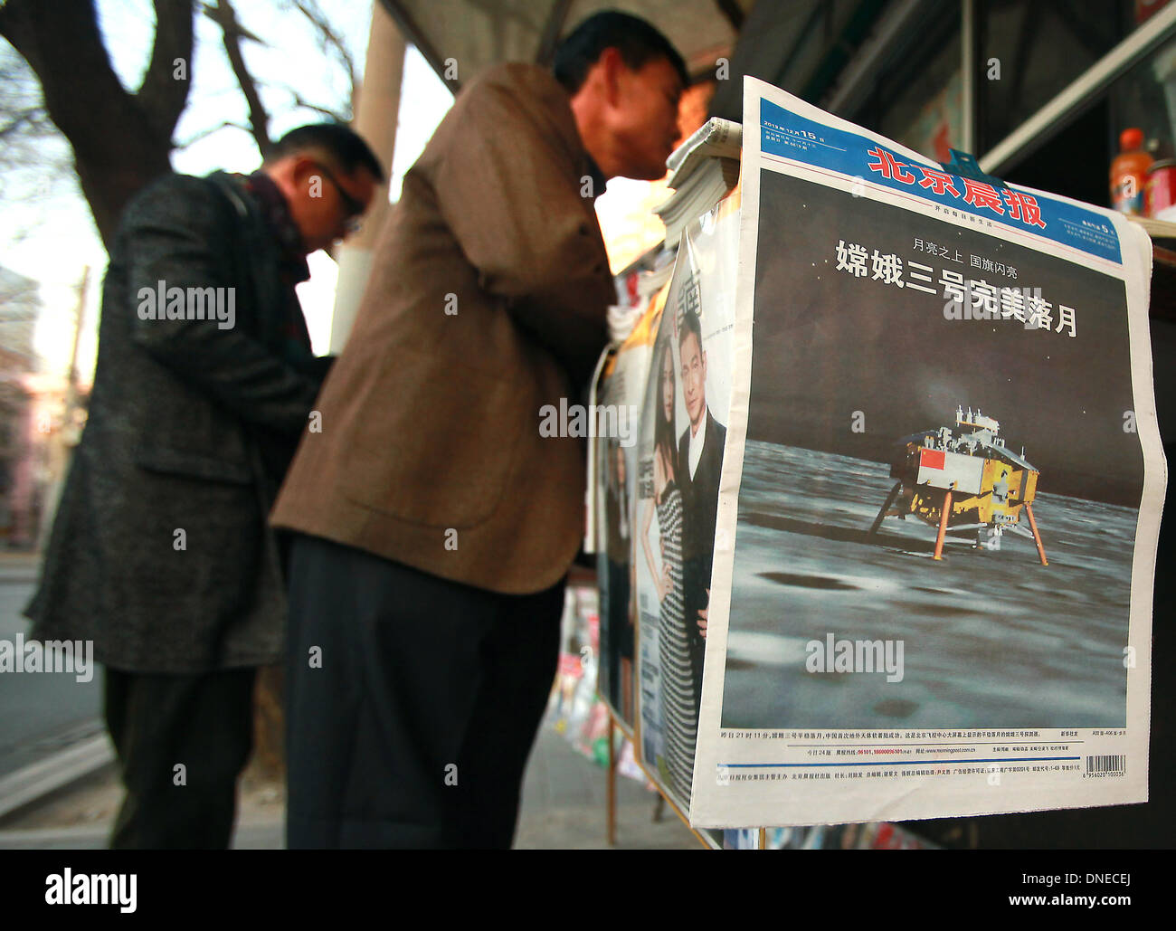 Beijing, CHINA, China. 15th Dec, 2013. China's lunar landing is run on the front page of leading Chinese newspapers being sold at a news stand in Beijing on December 15, 2013. China joined elite company yesterday with the controlled landing of its ''Jade Rabbit'' rover on the moon. China follows the U.S. and Soviet Union as the third country with a controlled - or ''soft'' - landing on the moon's surface. © Stephen Shaver/ZUMAPRESS.com/Alamy Live News Stock Photo