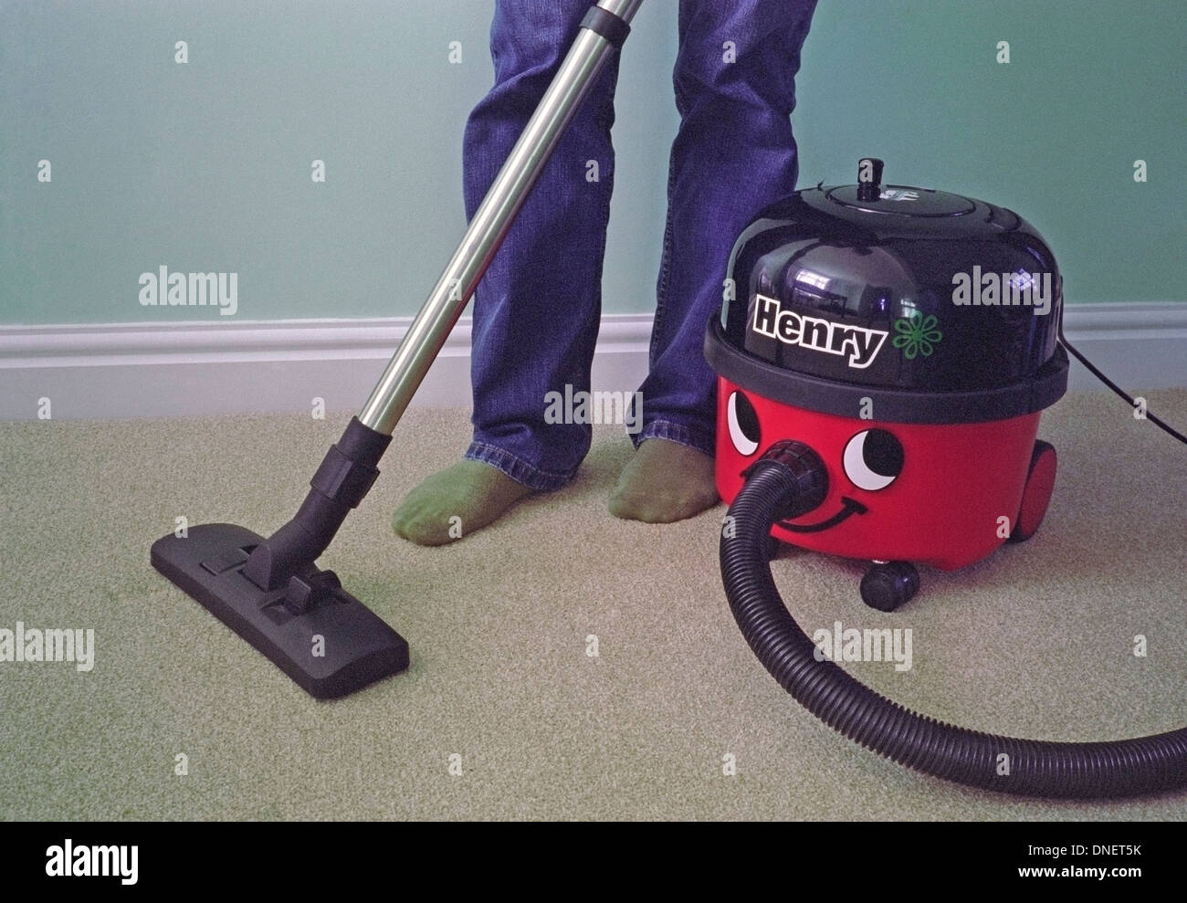 Caucasian Man Vacuuming a Carpet with a Henry Vacuum Cleaner MODEL RELEASED Stock Photo