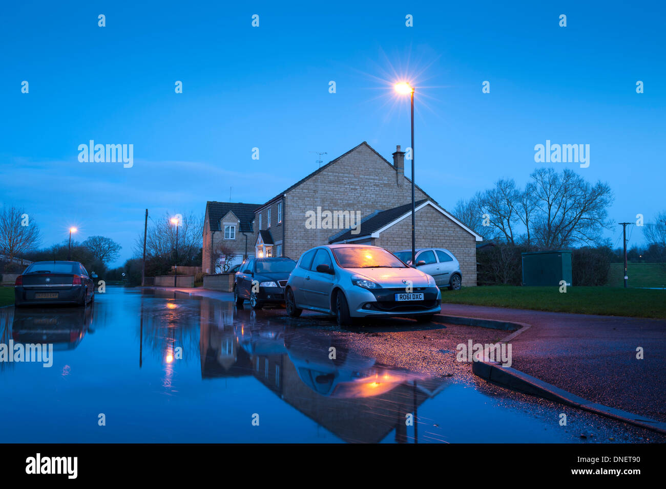 Malmesbury, Wiltshire, UK. 24th Dec, 2013. Christmas Eve after heavy storms hit the UK. The river Avon bursts it's banks, and floodwater creeps slowly up a road in the Wiltshire hillside town of Malmesbury. This time last year Malmesbury endured severe flooding making the national news. Credit:  Terry Mathews/Alamy Live News Stock Photo