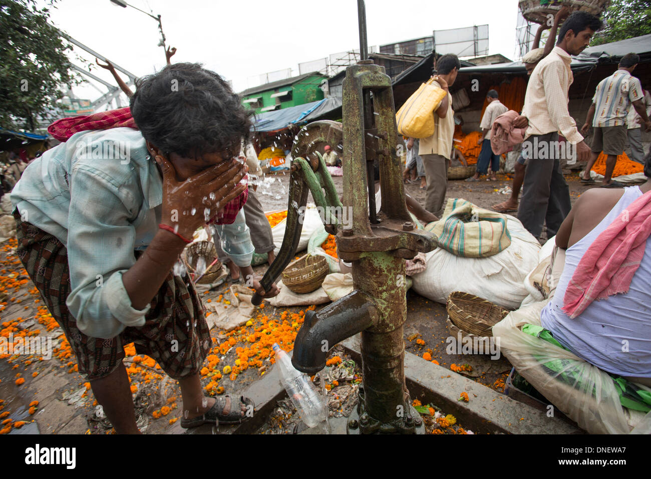 Man washing at well in Mallick Ghat Flower Market - Calcutta (Kolkata), India Stock Photo