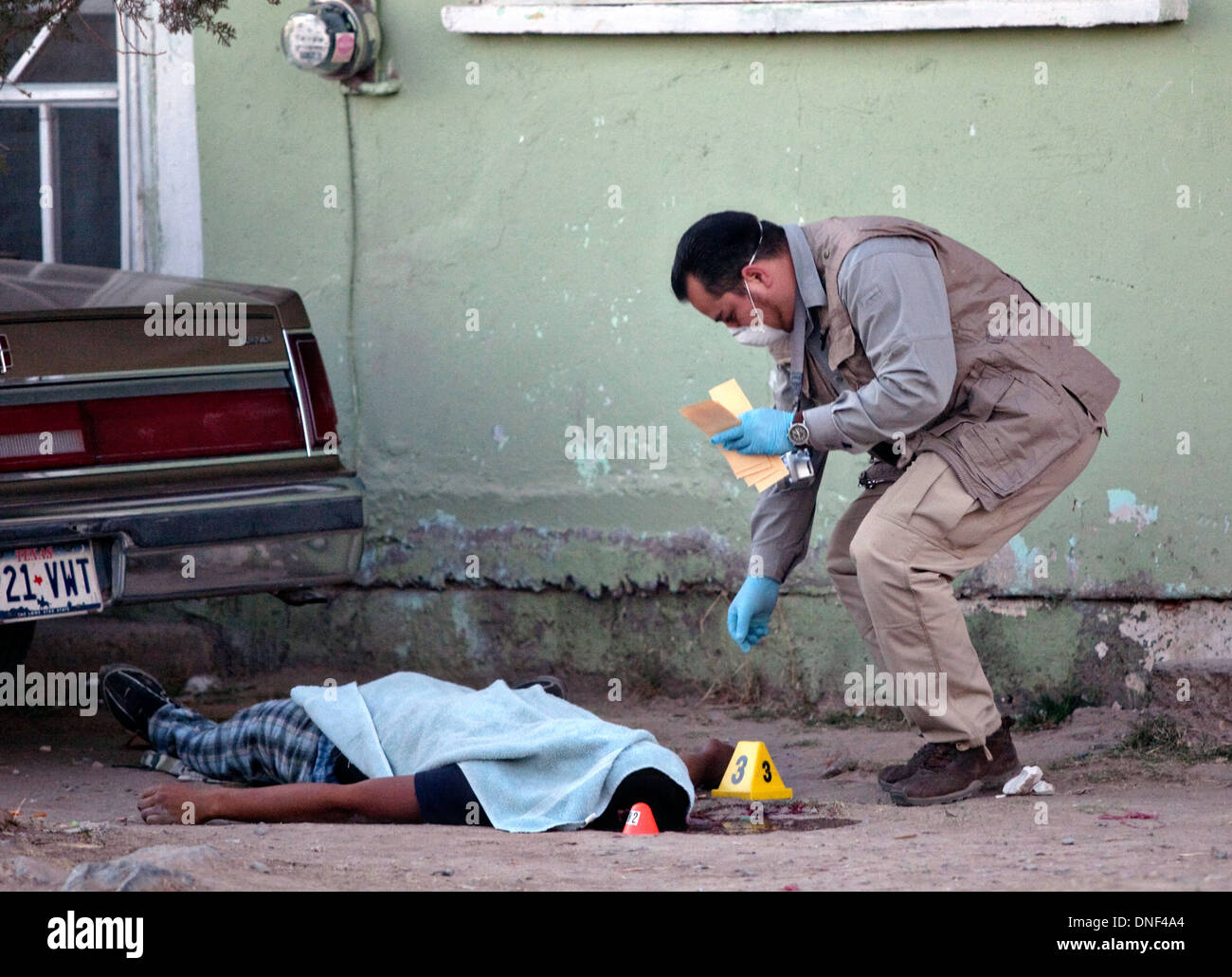 Police investigators at the scene of a drug related shoot out in a slum January 14, 2009 in Juarez, Mexico. The shooting, believed linked to the ongoing drug war which has already claimed more than 40 people since the start of the year. More than 1600 people were killed in Juarez in 2008, making Juarez the most violent city in Mexico. Stock Photo
