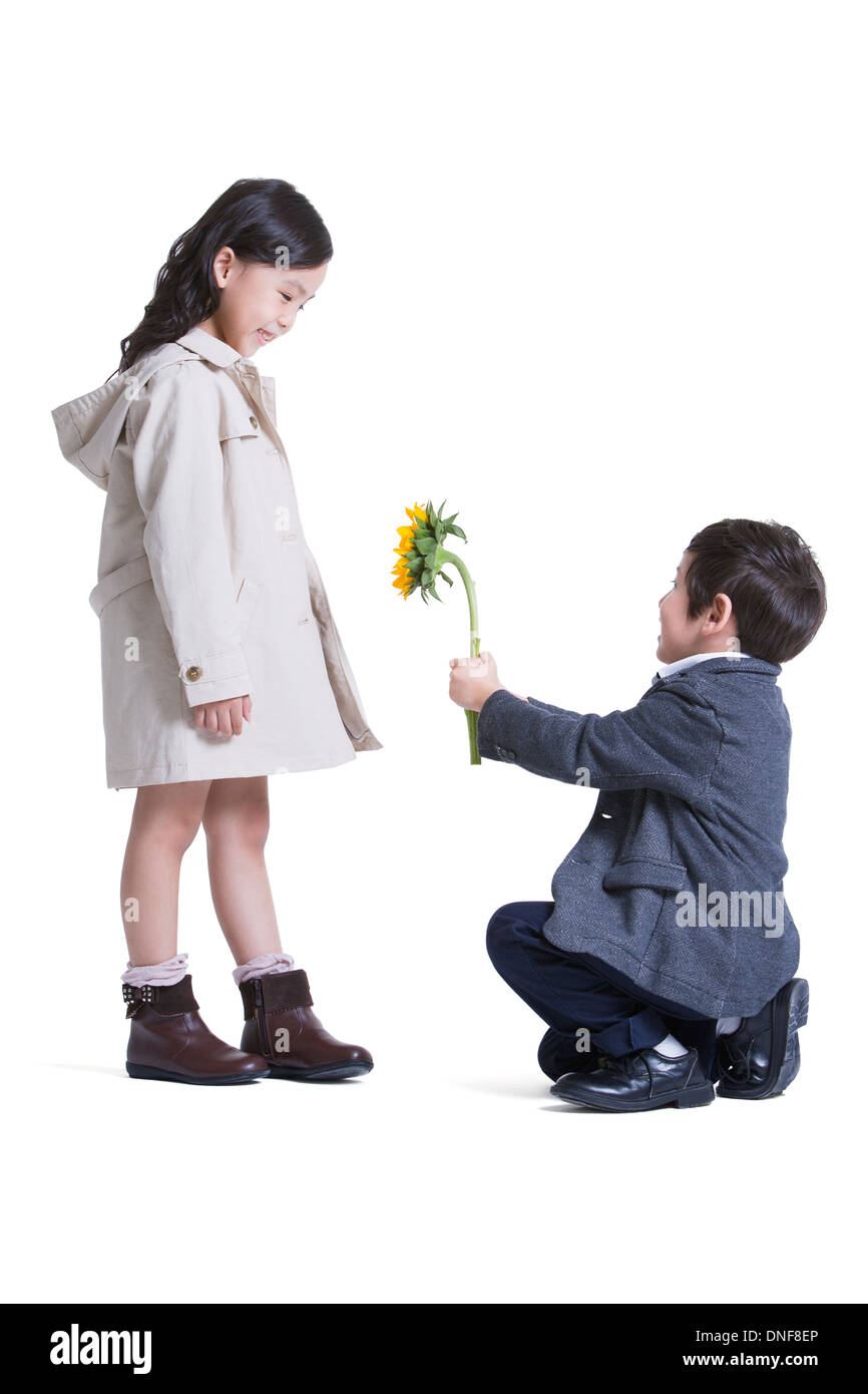Cute little boy kneeling and proposing to girl Stock Photo - Alamy