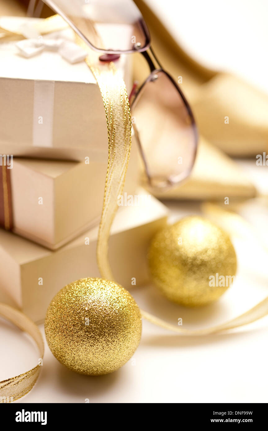 Golden balls with a pile of gift boxes and a pair of glasses in the background Stock Photo