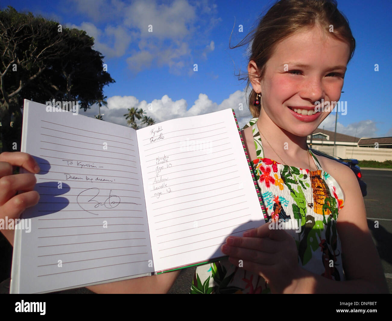 10-year-old Kyrstin Lavelle visiting from Toronto, Canada holds her notebook with a short quote, "Dream Big Dreams" with United States President Barack Obama's signature outside the McDonalds at Marine Corps Base Hawaii. Kyrstin was visiting her father who is active military outside the gym where President Obama exercises and shot a few baskets earlier this morning, December 24, 2013. Credit: Cory Lum / Pool via CNP Stock Photo