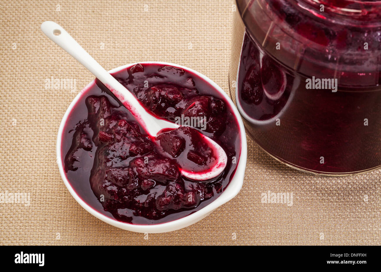 sugar free cranberry sauce with addition of blueberry, apples and honey - small bowl and jar Stock Photo