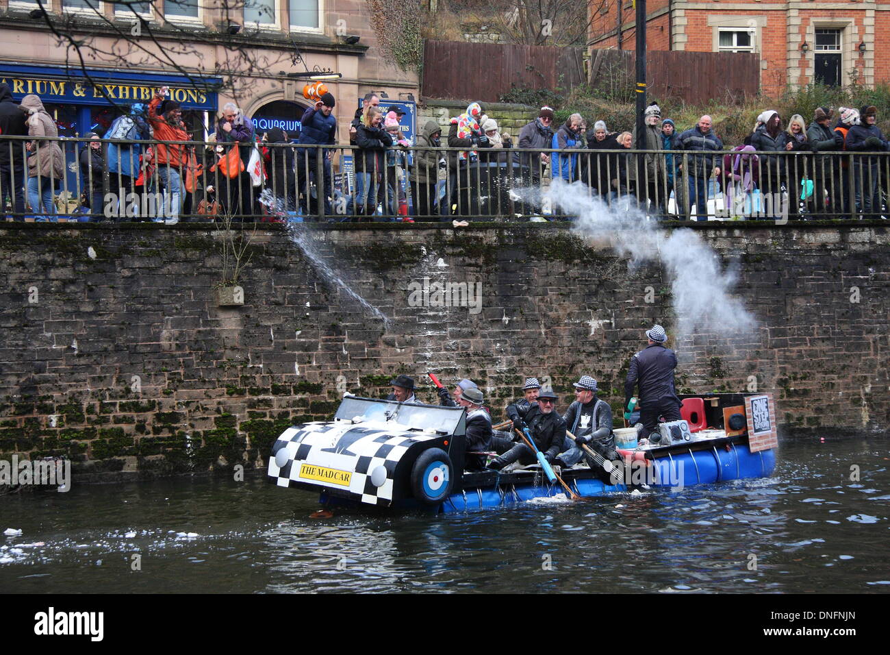 Spectators throw flour bombs at entrants of annual Boxing Day fancy dress raft race, River Derwent, Matlock Bath, Derbyshire UK Stock Photo
