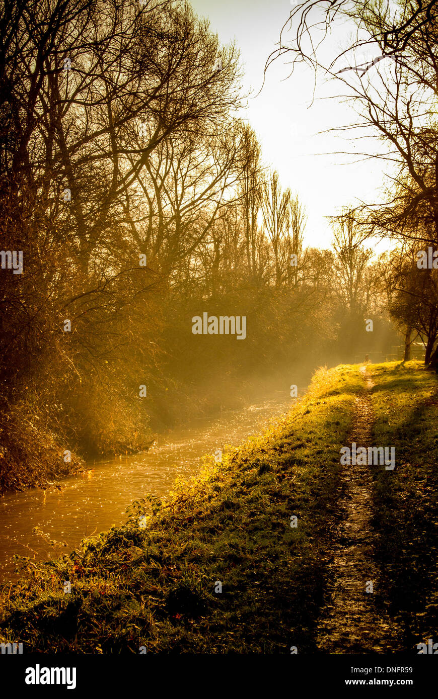 Riverside path in winter with mist and low sunshine. York, North ...