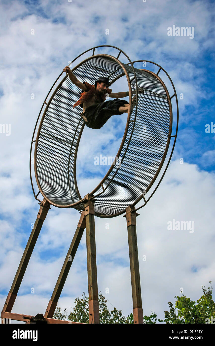Circus performer entertaining the public with his hamster wheel Stock Photo