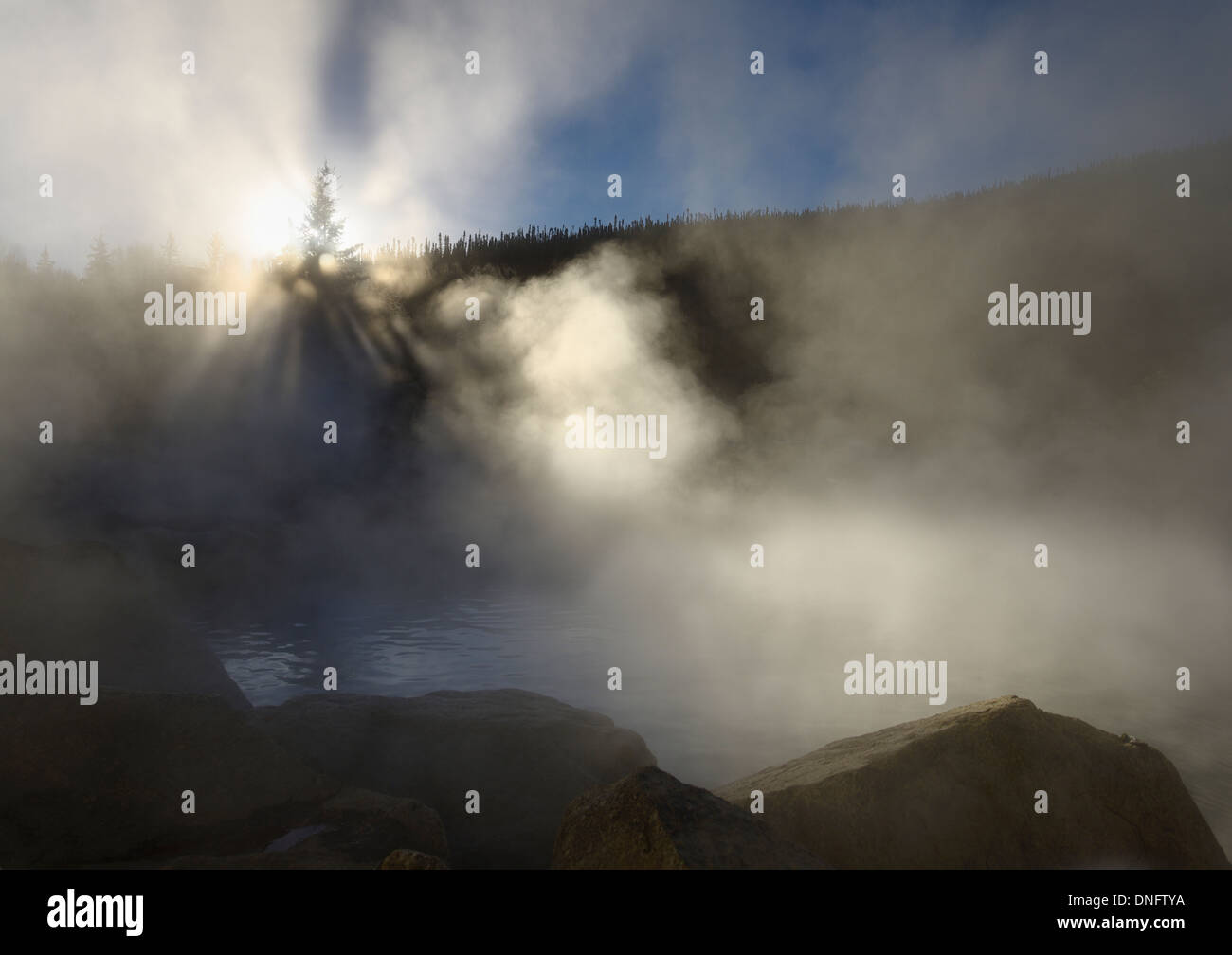 Sun beams in steam rising off of the Chena Hot Springs of Alaska USA in Fall Stock Photo