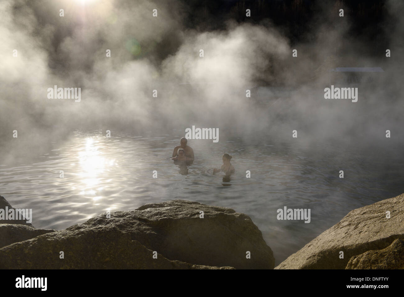 Tourists bathing in the hot outdoor pool with steam rising off of the Chena Hot Springs Alaska USA Stock Photo