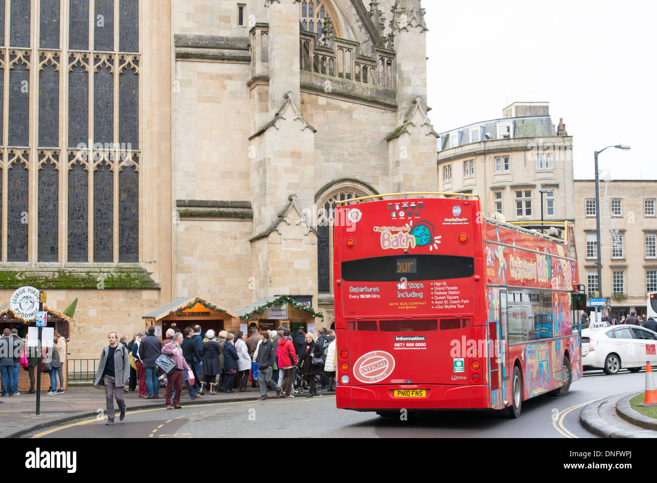 Open top Bath City Tours bus drives past Bath Abbey Stock Photo