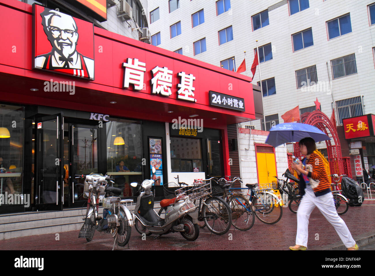 Beijing China,Chinese,Xicheng District,Guang An Men Nei Da Jie,Guanganmen Inner Street,Asian adult,adults,woman female women,umbrella,KFC,fast food,re Stock Photo