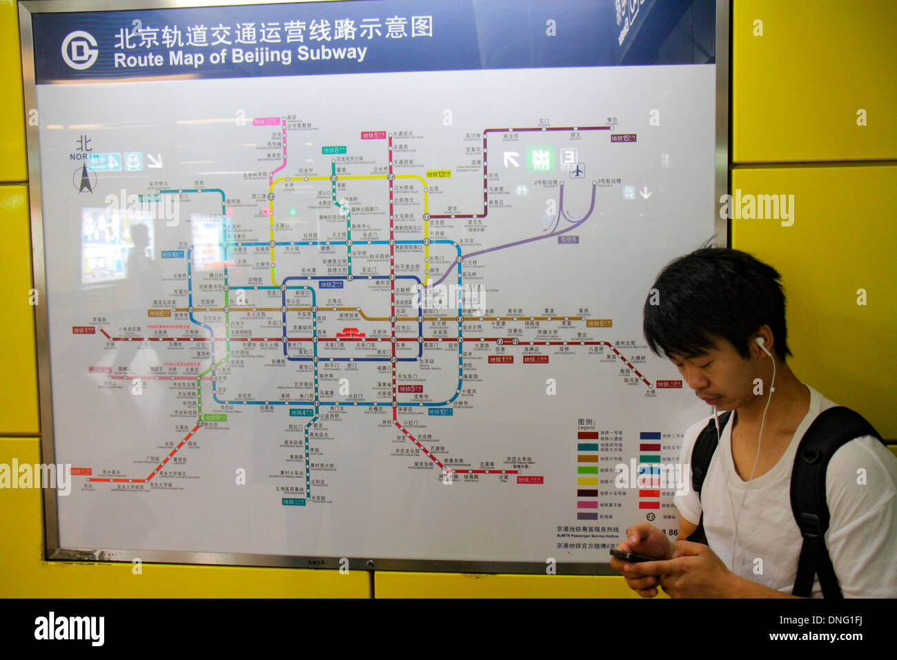 Beijing China,Chinese,Xuanwumen Subway Station,passenger passengers rider riders,rider,Asian man men male,Line 4,platform,waiting,smartphone cell phon Stock Photo