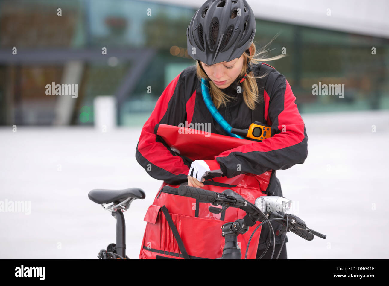 Female Cyclist Looking Through Courier Delivery Bag Stock Photo Alamy