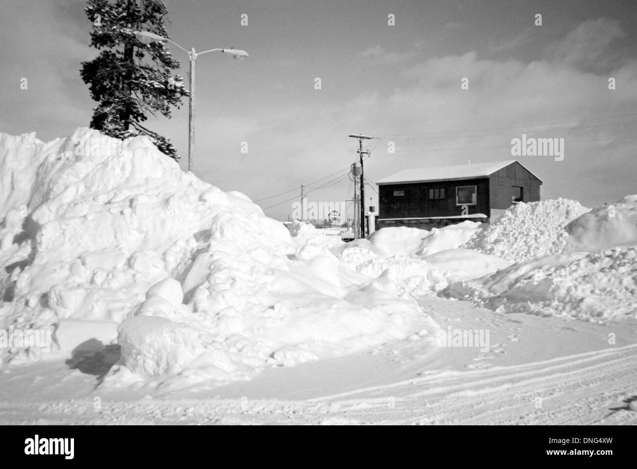 house standing amongst large snow drifts in west yellowstone montana
