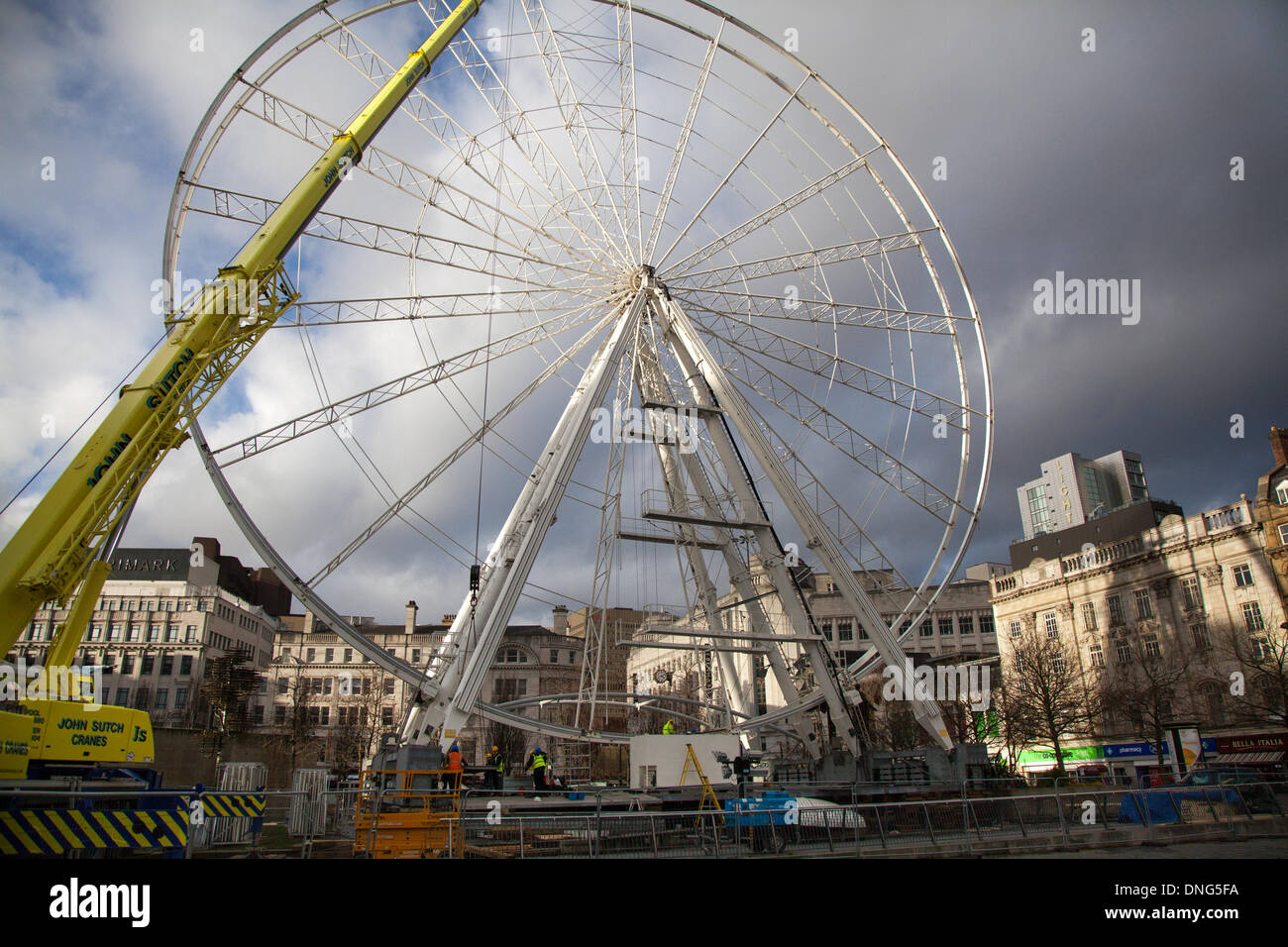 New Year Manchester, UK 27th December, 2013.     Manchester's New Year's Eve celebrations are poised to go off with a bang ... from Piccadilly Gardens, as the new big Ronald Bussink Professional Rides Ferris wheel takes centre stage. The 60m high ride – currently being built under difficult conditions– will officially open soon taking thrill-seekers up into the skies until 1am on January 1 2014.  It replaces the previous ride in Exchange Square, which was dismantled 18 months ago to make way for Olympic celebrations.  Conrad Elias/Alamy Live News Stock Photo