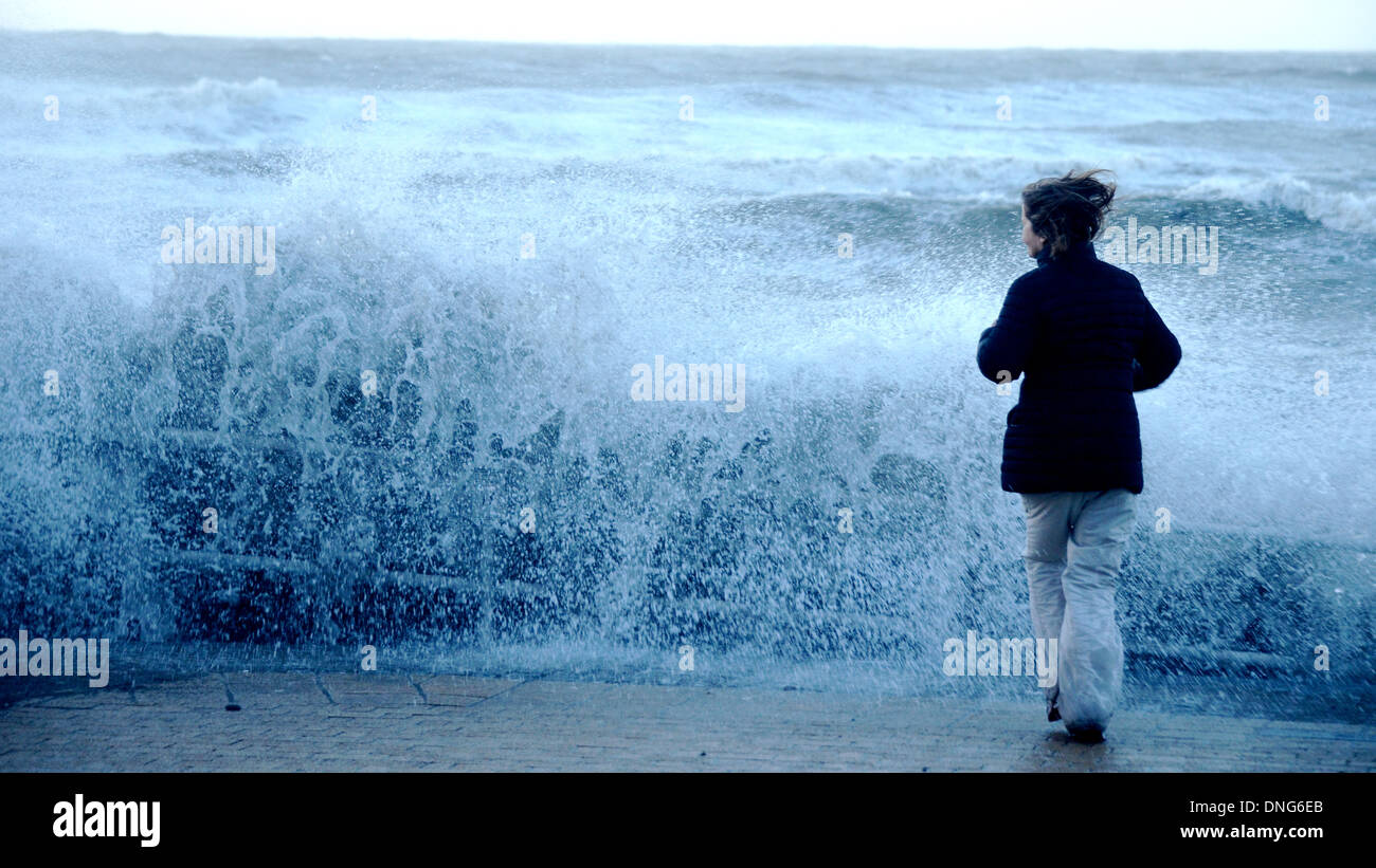 A woman is caught out by a wave whilst taking a photo, Aberystwyth Stock Photo