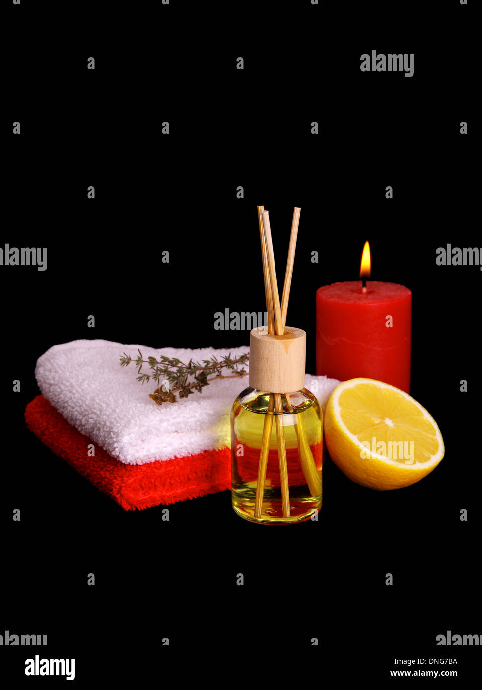 Yellow bottle with essential oil, candle and bath towels, vertical Stock Photo Alamy