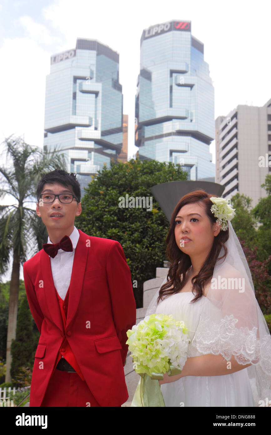 Hong Kong China,HK,Asia,Chinese,Oriental,Island,Central,Hong Kong Park,bride,groom,posing,red suit,dress,Asian man men male,adult,adults,woman female Stock Photo