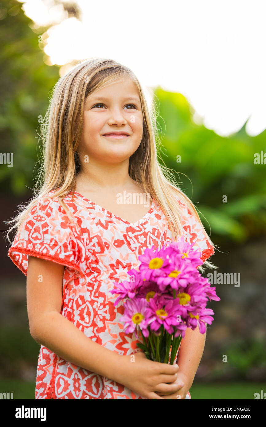 Cute happy little girl smiling outside with spring flowers Stock Photo ...