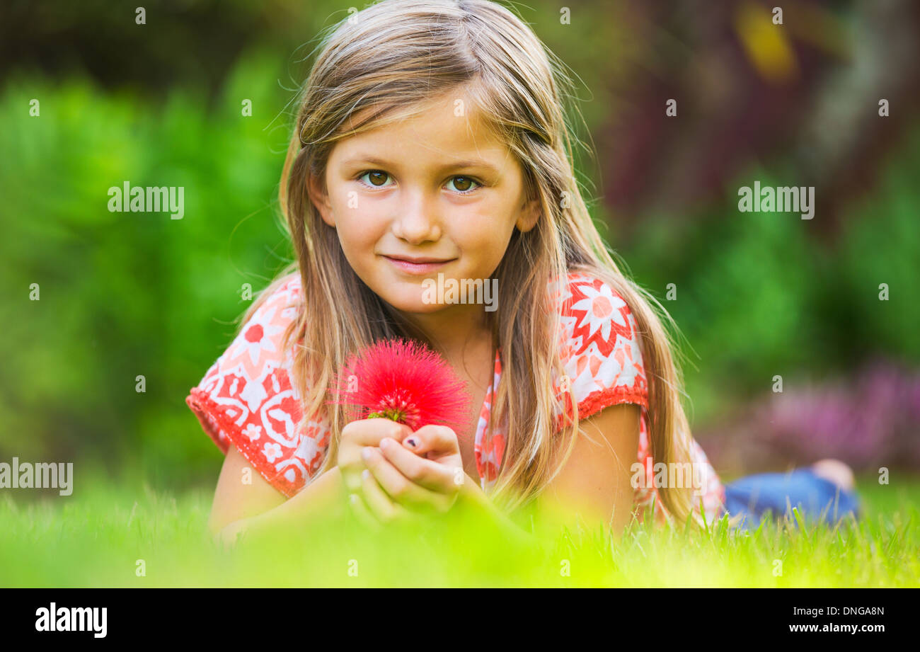 Cute happy little girl smiling outside on grass Stock Photo - Alamy
