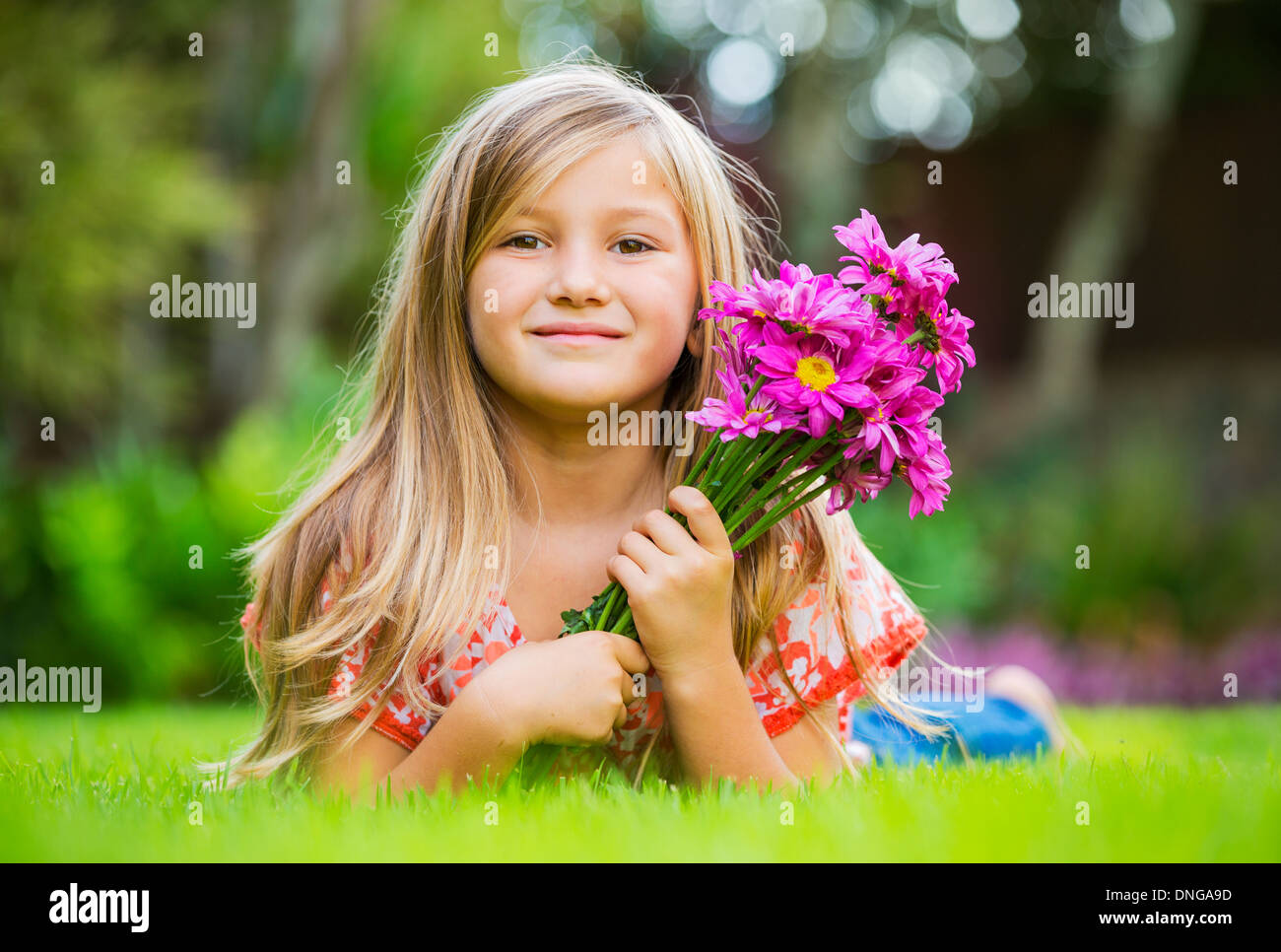 Cute happy little girl smiling outside on grass Stock Photo - Alamy