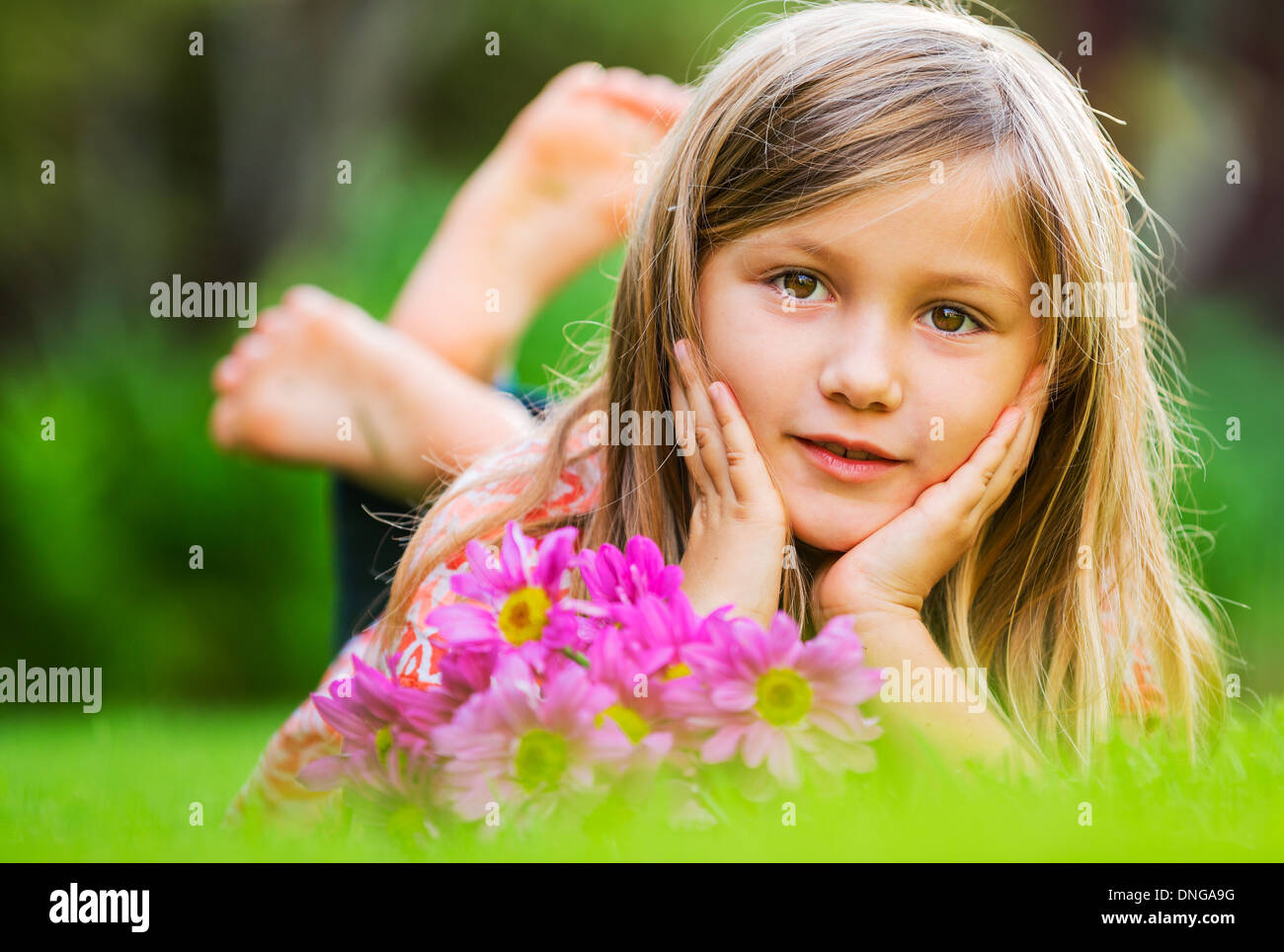 Cute happy little girl smiling outside on grass Stock Photo - Alamy