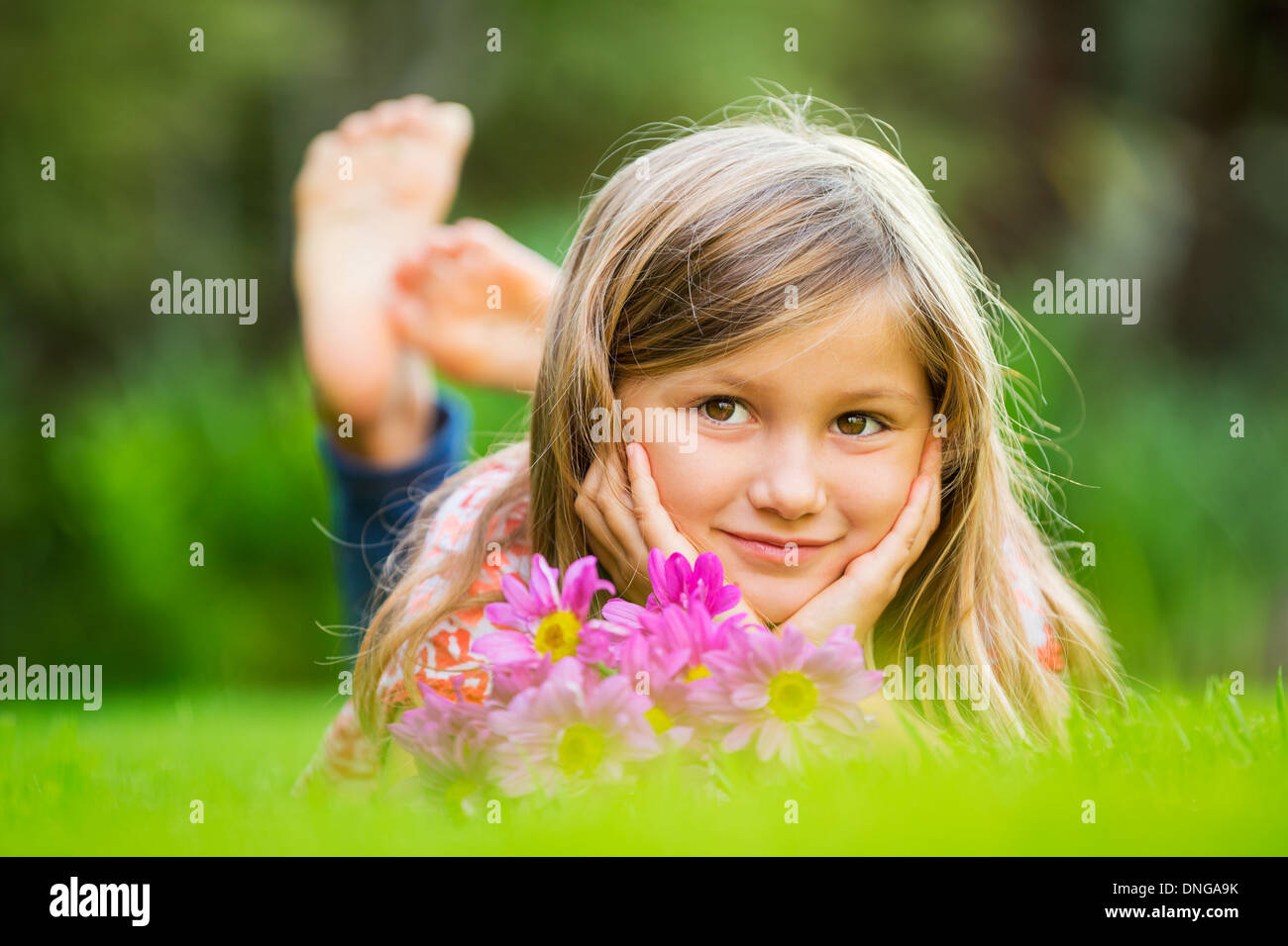 Cute happy little girl smiling outside on grass Stock Photo - Alamy