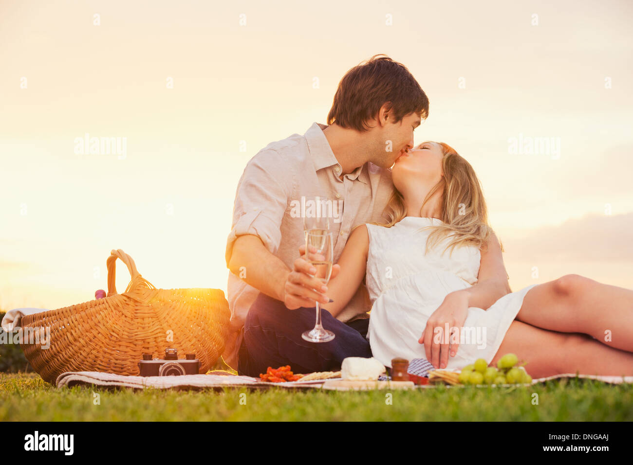 Attractive couple kissing on romantic sunset picnic Stock Photo - Alamy