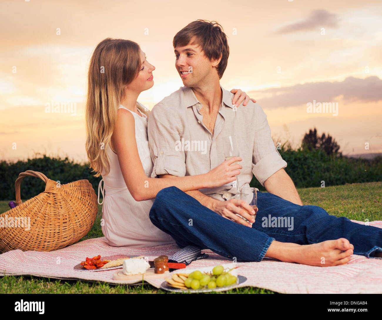 Attractive couple on romantic sunset picnic in countryside Stock Photo