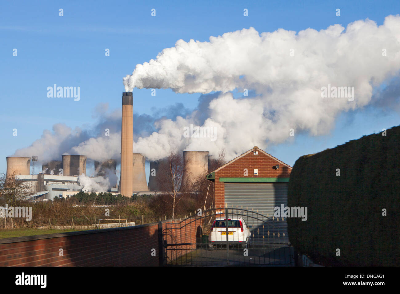 Eggborough Power Station a large coal fired power station in North Yorkshire, England bellowing smoke into the sky behind a home Stock Photo