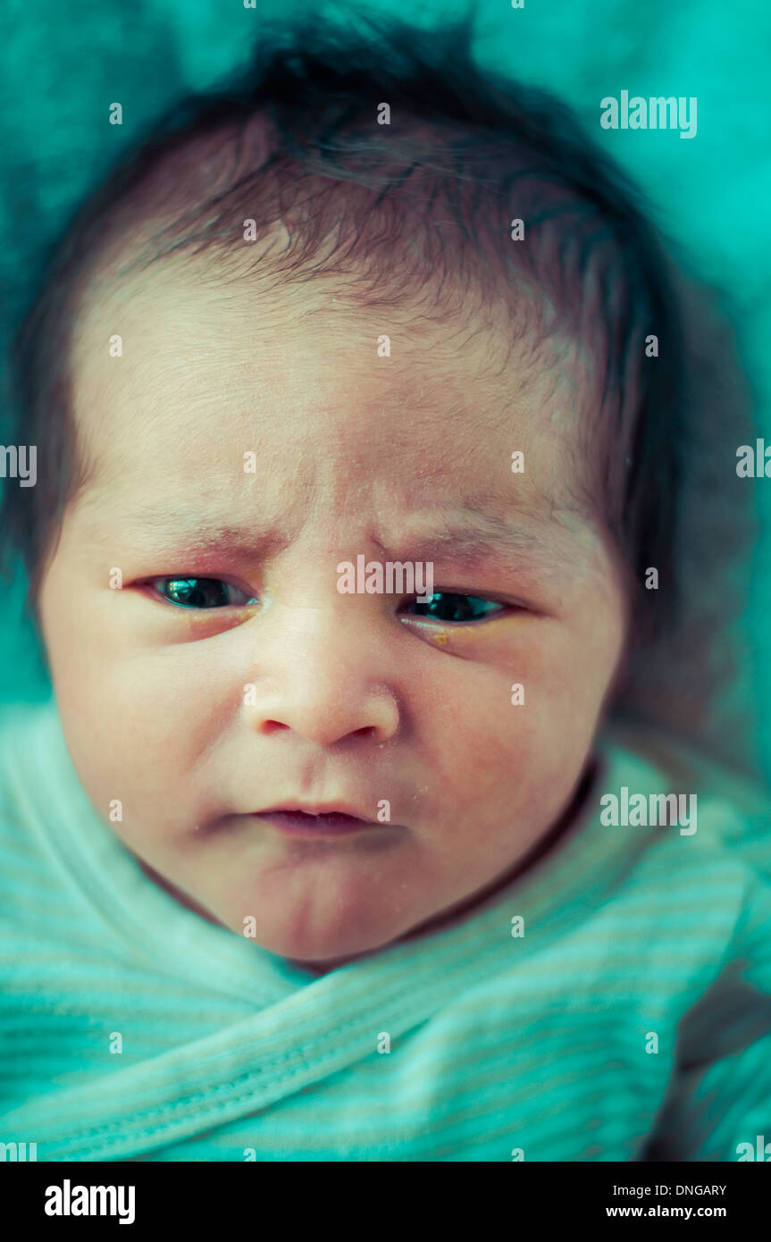 Newborn peacefully sleeping, picture of a baby curled up sleeping on a