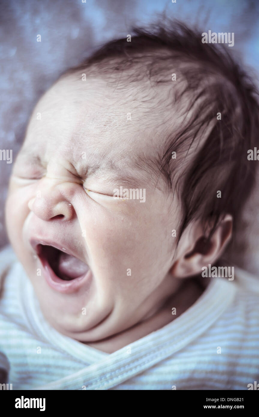 new born baby curled up sleeping on a blanket, multiple expressions