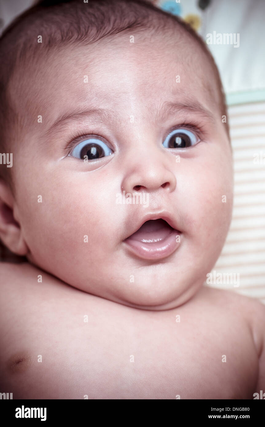 new born baby curled up sleeping on a blanket, multiple expressions