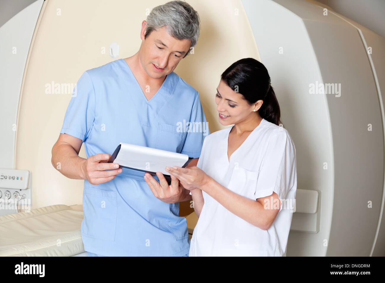Technicians Looking At Clipboard Stock Photo
